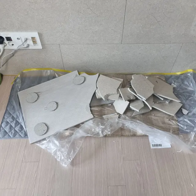 떼어낸 타일 조각 — 깨진 아트월 타일 교체 (관리사무소에서 받은 타일로)